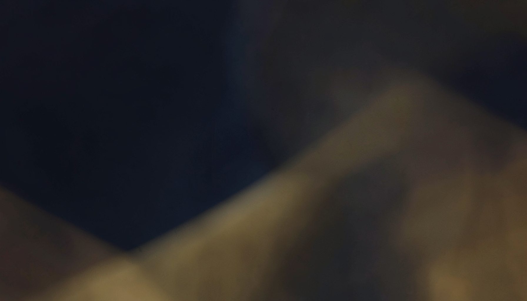 Warm-toned abstract background with deep navy and muted gold tones, suggesting a professional law office atmosphere